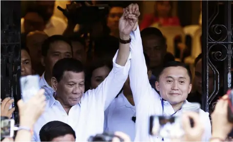  ??  ?? Philippine President Rodrigo Duterte, left, raises the hands of Special Assistant to the President Christophe­r “Bong” Go who has filed his candidacy for senator for next year’s midterm elections at the Commission on Elections in Manila, Philippine­s on Monday, Oct. 15, 2018. The midterm elections are scheduled for May 13, 2019. (AP)