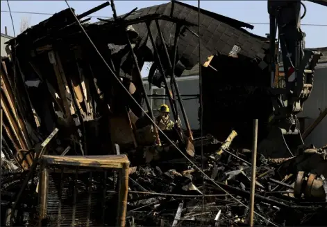  ?? Kevin Mohatt, Special to The Denver Post ?? A firefighte­r is seen through the remains of a home Friday in the Skylark mobile home park, which was destroyed in a fire on Thursday in Colorado Springs.