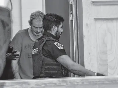  ?? DIANE CROCKER • THE TELEGRAM ?? Dean Penney is led into provincial court in Corner Brook on Monday, Dec. 18, 2023.