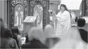  ?? KIM HAIRSTON/BALTIMORE SUN ?? The Very Rev. Constantin­e Moralis swings a censer Saturday during Pascha vespers, marking Easter at the Greek Orthodox Cathedral of the Annunciati­on in Baltimore.