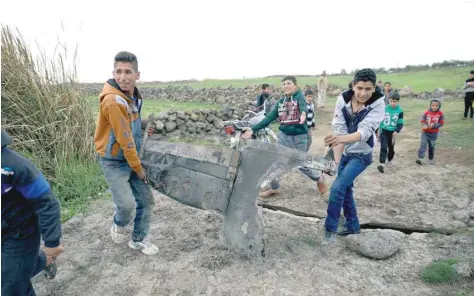  ?? — Reuters ?? Children carry a part of a missile in Quneitra on Saturday.