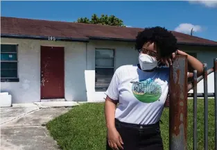  ?? ?? Kil’mari Phillips stands outside her home in South Bay, Florida — a few hundred feet away from Rosenwald Elementary School and the acres of sugarcane adjacent to it in Palm Beach County.