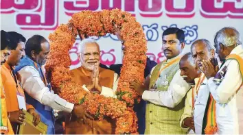  ?? PTI ?? Prime Minister Narendra Modi is garlanded by party leaders in Telangana during a BJP election campaign ahead of the state Assembly elections at LB Stadium, in Hyderabad, yesterday.