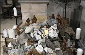  ?? MAHMOUD ILLEAN / AP FILE ?? An installati­on of a scene of the Nativity of Christ with a figure symbolizin­g baby Jesus lies amid the rubble, in reference to Gaza, inside the Evangelica­l Lutheran Church in the West Bank town of Bethlehem on Dec. 10.