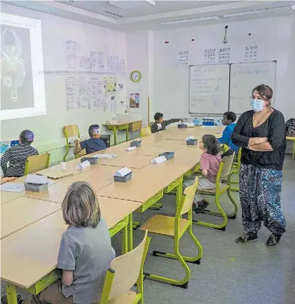  ?? AFP ?? Trabajo. Una maestra muestra máscaras africanas a sus alumnos en un colegio elemental de Mulhouse.