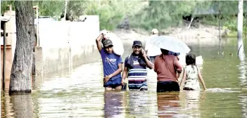  ?? — AFP file phoro ?? Residents wade through a flooded street in Dili last week after torrential rains from Tropical Cyclone Seroja killed more than 200 people across East Timor and neighbouri­ng eastern Indonesia.