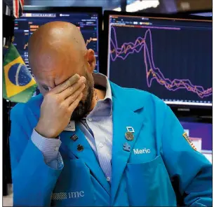  ?? AP/RICHARD DREW ?? Specialist Meric Greenbaum takes a moment Friday on the floor of the New York Stock Exchange as stocks dived in a sweeping sell-off after China announced new tariffs on $75 billion in U.S. goods.