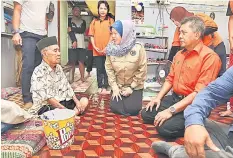  ??  ?? Azizah speaks to a senior citizen during a home visit.