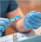  ?? ADAM CAIRNS/COLUMBUS DISPATCH, ?? Pharmacist Eamonn Kerrigan prepares doses of the Moderna COVID-19 vaccine at Mount Carmel East hospital. The Ohio House Health Committee is considerin­g legislatio­n that would weaken state vaccinatio­n laws.