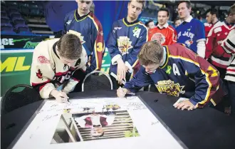  ?? KAYLE NEIS/THE CANADIAN PRESS ?? Attendants signed a poster of Evan Thomas during the Humboldt Broncos player’s funeral in Saskatoon Monday.