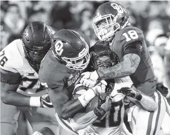  ?? AP PHOTO/IAN MAULE ?? Oklahoma defensive end Ronnie Perkins (7) and linebacker Curtis Bolton (18) tackle Oklahoma State running back Chuba Hubbard during Saturday’s game in Norman, Okla. The Sooners won 48-47.