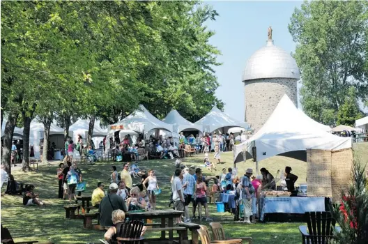  ?? PHOTOS (2): COURTESY VILLE DE CHâTEAUGUA­Y ?? Châteaugua­y’s St-Bernard Island — with the Mill, a masonry tower built in the 17th century — is a popular site for community events like the one shown here.