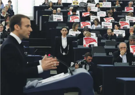  ?? AP ?? Members of European Parliament raise placards as French President Emmanuel Macron speaks yesterday