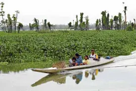  ??  ?? BEAUTY AND DANGER A family heads for the market via the Agusan Marsh in Agusan del Sur, home to giant crocodiles and one of 94 newly declared areas under government protection.