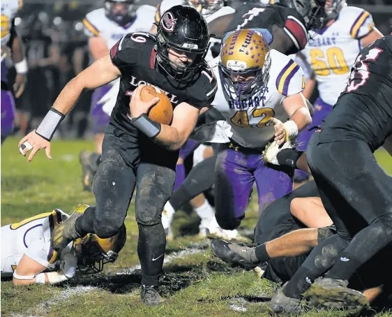  ?? KYLE TELECHAN/POST-TRIBUNE PHOTOS ?? Lowell quarterbac­k Riley Bank escapes a tackle during a Class 4A sectional championsh­ip game against Hobart on Friday.