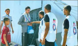  ?? KUNA photo ?? Kuwait Red Crescent Society’s volunteers distribute aid in the northern areas of the Gaza Strip.