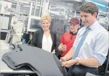  ?? DAVID BEBEE, RECORD STAFF WATERLOO REGION RECORD ?? Prime Minister Justin Trudeau inspects a part at Cambridge’s Toyota plant with Premier Kathleen Wynne and Toyota employee Kyle McCaig on Friday.