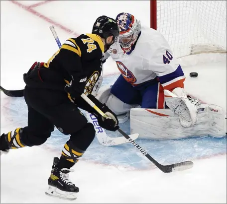  ?? MICHAEL DWYER — THE ASSOCIATED PRESS ?? Boston Bruins’ Jake DeBrusk scores against New York Islanders goalie Semyon Varlamov during the first period Saturday at the TD Garden in Boston.