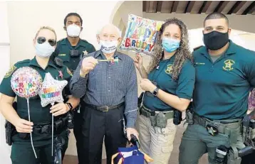  ?? HOWIE SONNENSCHE­IN ?? Holocaust survivor Julius Eisenstein of Hallandale Beach with Broward Sheriff’s Office police officers who provided escort for his 101st drive-by birthday caravan.