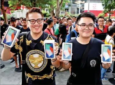  ?? REUTERS ?? First customers to buy iPhone X, Kittiwat Wang, 22, and Mod, 22, of Bangkok pose with their iPhone X at the Apple store in Singapore on Friday.