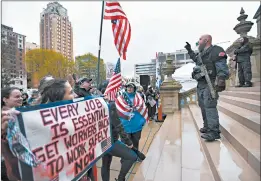  ?? MATTHEW DAE SMITH/LANSING STATE JOURNAL ?? Protesters rally to denounce Gov. Gretchen Whitmer’s stay-at-home order and business restrictio­ns due to COVID-19 on April 30 at the state Capitol in Lansing, Michigan.