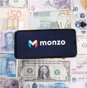  ??  ?? A smartphone displays a Monzo logo on top of banknotes in this illustrati­on.