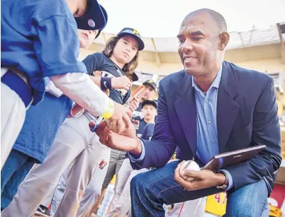  ?? ROBERTO E. ROSALES/JOURNAL ?? Former Albuquerqu­e Duke and Los Angeles Dodger pitcher Ramon Martinez signs autographs on Saturday at Isotopes Park.