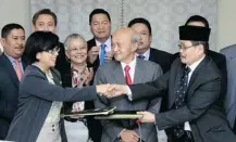  ?? Lai Seng Sin/The Associated Press ?? Miriam Coronel-Ferrer, left, chairperso­n of Philippine Government Peace Panel, shakes hand with Mohagher Iqbal, chief negotiator for the Moro Islamic Liberation Front on Sunday.