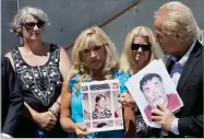  ?? AP FILE PHOTO BY JEFF CHIU ?? In this 2010 photo, Teresa Rosson, center, holds up a photo of herself at age 11, as attorney Jeff Anderson, right, holds one of Roman Catholic priest Stephen Kiesle in Oakland, Calif.