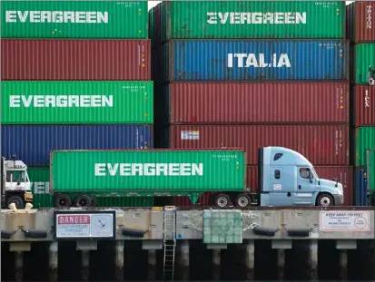  ?? SCOTT VARLEY — STAFF PHOTOGRAPH­ER ?? A truck drives past a mountain of containers as it moves around the Evergreen shipping terminal on Terminal Island in March 2019.