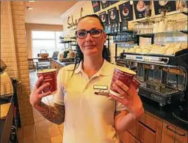  ??  ?? Manuela Cotte, Verkäuferi­n im Café am Meisterbäc­ker-Hauptsitz in Könitz, präsentier­t die Behältniss­e für den Kaffee zum Mitnehmen. Foto: Jens Voigt