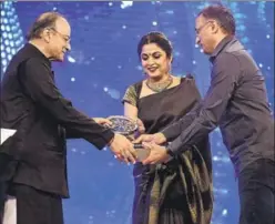  ??  ?? Ramya Krishnan and Shobu Yarlagadda receive the award for outstandin­g achievemen­t on behalf of Team Baahubali.