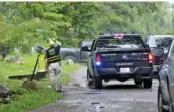  ?? STAFF PHOTO BY ERIN O. SMITH ?? A Georgia Bureau of Investigat­ion agent lifts crime scene tape Monday for a Walker County Sheriff’s deputy to exit the scene during a police-involved shooting and stabbing investigat­ion in Walker County, Ga.