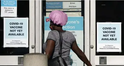  ?? AP ?? NOT YET: A customer walks past a sign saying the coronaviru­s vaccine is not available at a California Walgreens. Interpol has issued a warning that orgainzed crime may look to cash in with fake or stolen vaccines.