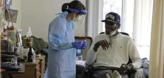  ?? AP file ?? CHECKING THE SPREAD: Dr. Gabrielle Beger, left, prepares to take a nose-swab sample from Lawrence McGee, at Queen Anne Healthcare, a skilled nursing and rehabilita­tion facility in Seattle. Conducting universal testing at such facilities is key to controllin­g the spread of the coronaviru­s.