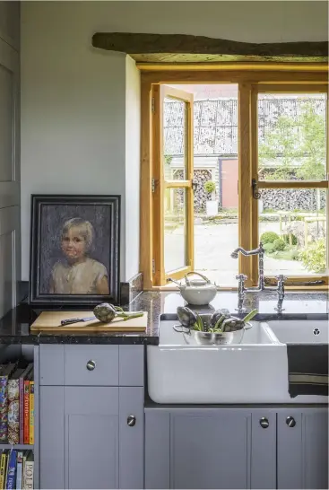  ??  ?? ABOVE The kitchen window looks out across the old farmyard to one of the old barns. Juliette has adapted the tted kitchen by painting the doors Farrow & Ball’s ‘Manor House Gray’ and removing the wall units to create a central island FACING PAGE French...