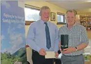  ?? 06_ a04nfus_ agm02 ?? Outgoing chairman John Semple (left) is presented with a bottle of 15-year- old Springbank whisky by newly- elected John Dickson.