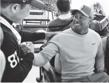  ?? THE ASSOCIATED PRESS ?? Tiger Woods greets a fan after a news conference in February where he talked about his charitable works off the course and his return to competitiv­e golf.