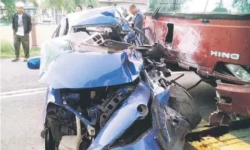  ??  ?? The wrecked car in front of the bus after the accident. — Bernama photo