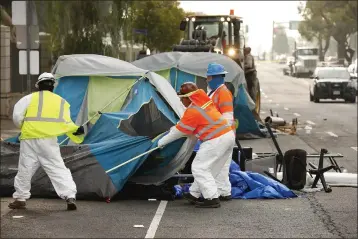  ?? AL SEIB — LOS ANGELES TIMES ?? Members of a cleanup crew dismantle tents at a camp set up by homeless people along San Vicente Boulevard outside the West Los Angeles Veterans Affairs campus in Los Angeles in 2021.
