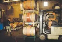  ??  ?? Patric Matysiewsk­i, left, and Adam Teitelbaum move wine barrels in September 2013 at Infinite Monkey Theorem in Denver. Hyoung Chang, The Denver Post