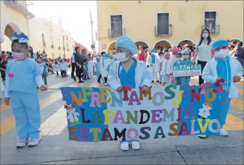  ?? ?? El grupo de niños de Valladolid vestidos de médicos que marchó en el desfile por el aniversari­o de la Revolución, y agradeció a los médicos la lucha contra el Covid-19