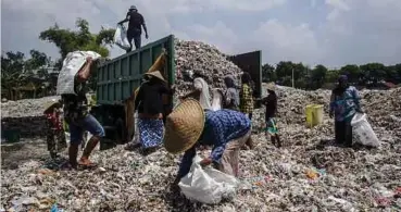  ??  ?? PENCARI barangan terbuang memilih
bahan plastik di pusat pembuangan di Mojokerto, Jawa
Timur. - EPA