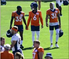  ?? ANDY CROSS — THE DENVER POST ?? From left: Broncos cornerback­s Ja’quan Mcmillian, P.J. Locke and safety Justin Simmons enter the field for Denver Broncos Back Together Weekend training camp practice at Centura Health Training Center in Centennial on July 29.