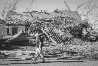  ?? Alex Slitz / Tribune News Service ?? Retired history professor and Mayfield native Berry Craig, of Arlington, Ky., walks past a home damaged by a recent tornado in Mayfield.