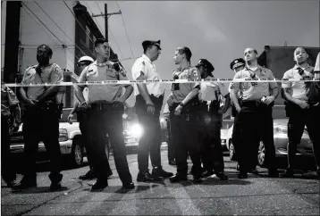  ?? ASSOCIATED PRESS ?? OFFICERS GATHER FOR CROWD CONTROL NEAR A MASSIVE POLICE PRESENCE set up outside a house as they investigat­e a shooting in Philadelph­ia on Wednesday. Philadelph­ia police Sgt. Eric Gripp said early Thursday morning that the man was taken into custody after an hourslong standoff with police in which six officers were injured.