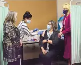  ?? JIM THOMPSON/JOURNAL ?? First lady Jill Biden, right, and Gov. Michelle Lujan Grisham, left, watch Wednesday as Viviana Galvez receives her COVID-19 vaccinatio­n at First Choice Community Healthcare, South Valley Medical Center.