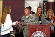  ?? CONTRIBUTE­D PHOTOS ?? Sgt. Christian H. Craig, Radnor High School Class of 1999, presents Senior Class President Anna Duffy with a flag in recognitio­n of the class’s contributi­ons to servicemen and women over the past four years.