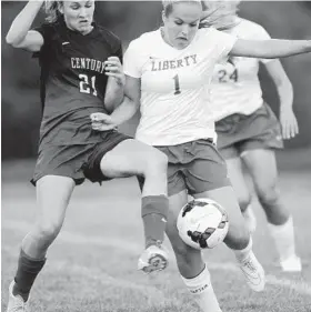  ?? STEVE RUARK/PHOTOS FOR THE BALTIMORE SUN ?? Century’s Hailey Turney, left, and Liberty’s Abbey Butler battle for the ball in the first half Tuesday. Century has not lost a Carroll County game since the 2011 season.