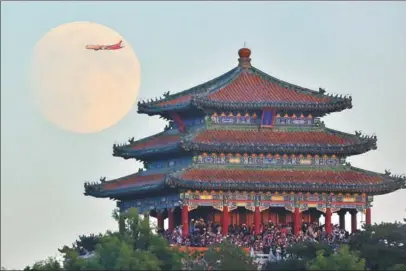  ?? BAI JIKAI / FOR CHINA DAILY ?? A plane flies across a full moon that provides a timely backdrop to Wanchun Pavilion in Beijing, Sept 23, 2018.